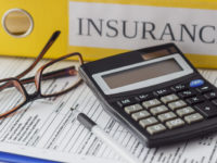 Clean insurance form, folders, pen, glasses and calculator