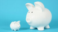 Two piggy banks, one big and one small, on a bright blue background