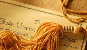 Gold tassel on a check written for college tuition Gold tassel on a check written for college tuition