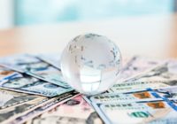 Glass globe and US dollar bills