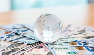 Glass globe and US dollar bills