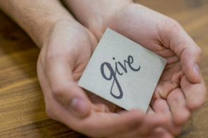 Man holding 'give' message