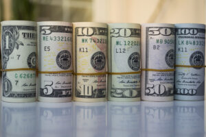 Us Dollars banknotes rolls on white background with reflection