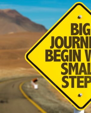 Big Journeys Begin With Small Steps sign with sky background