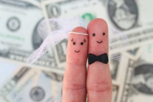 Fingers art of a Happy couple. Bride and groom hug on background of money. Concept of arranged marriage.