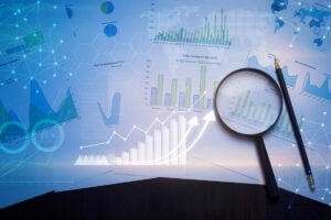 Magnifying glass and documents with analytics data lying on table , and digital virtual reality graph