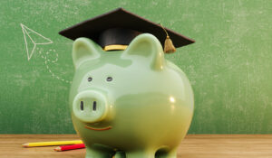 Green piggy bank wearing graduation hat in front of green chalkboard with copy space. Scholarship savings concept background. 3D Rendering, 3D Illustration