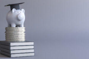 By stacks of shiny coins signifying college expense or potential new earnings.