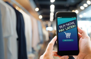 Hands holding mobile phone on blurred store as background