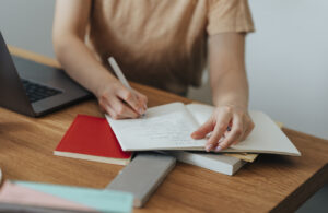 A Brief To-Do List Hands of an unrecognisable woman sitting at her office desk and writing new and creative ideas in her notebook