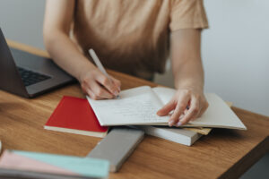 A Brief To-Do List Hands of an unrecognisable woman sitting at her office desk and writing new and creative ideas in her notebook